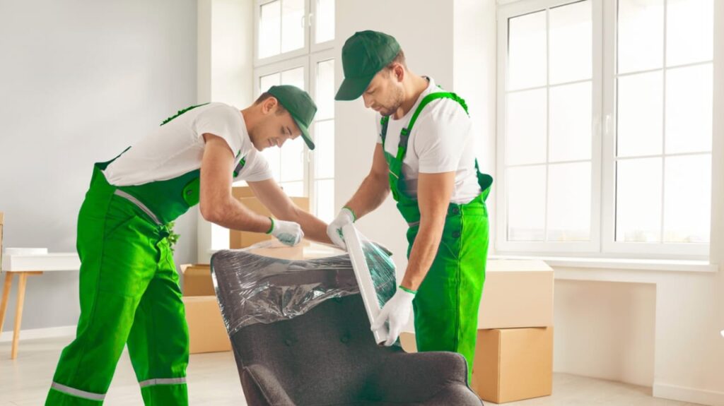 Two Madhu Home Logistics staff carefully packing a chair in Hyderabad
